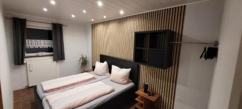 um quarto com 2 camas e almofadas brancas em Ferienwohnung Müller em Wadern