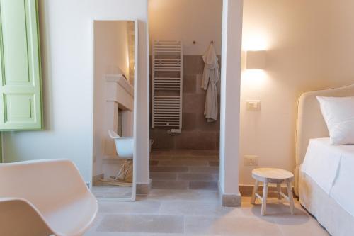 a bedroom with a bed and a bathroom with a sink at Masseria Egnazia - Epoca Collection in Savelletri di Fasano