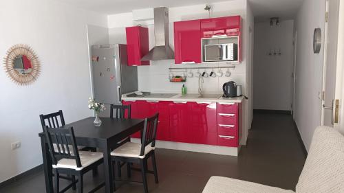 プエルト・デ・サンティアゴにあるLago de Santiagoのキッチン(赤いキャビネット、黒いテーブルと椅子付)