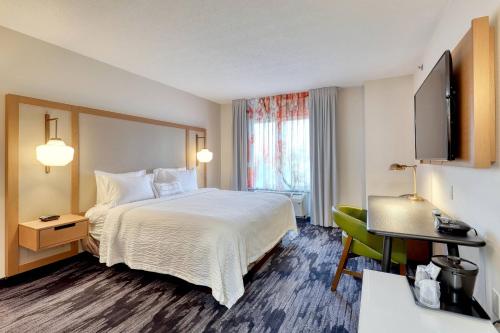 a hotel room with a bed and a desk at Fairfield Inn & Suites Woodbridge in Avenel
