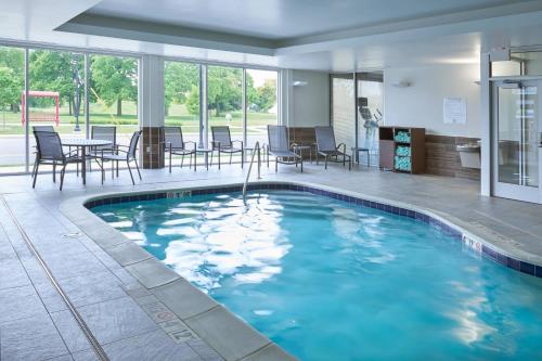 米德蘭的住宿－Fairfield Inn & Suites by Marriott Midland，大楼内一个带椅子和桌子的游泳池