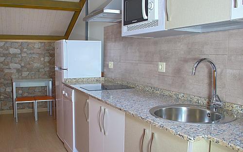 a kitchen with a sink and a refrigerator at Aire de Sanabria in El Puente