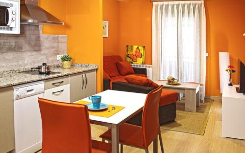 a kitchen and living room with a table and chairs at Aire de Sanabria in El Puente