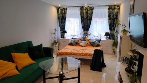 a living room with a bed and a green couch at Apartament u Danusi in Złoty Stok