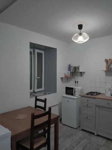 - une cuisine avec une table, une table et des chaises dans l'établissement Studio agréable et fonctionnel à 5km des plages, à Lannion
