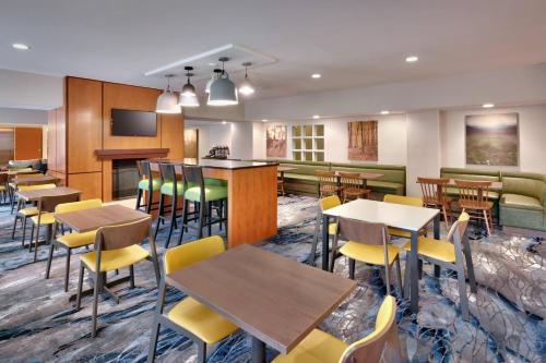 a restaurant with tables and chairs and a bar at Fairfield Inn & Suites Seattle Bellevue/Redmond in Bellevue