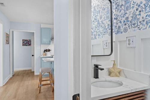 baño con lavabo y azulejos azules y blancos en The Blue Lagoon, en Pine Knoll Shores
