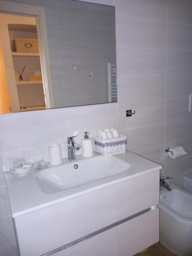ein weißes Badezimmer mit einem Waschbecken und einem Spiegel in der Unterkunft Appartamentino - Castle view, no stairs in Dolceacqua