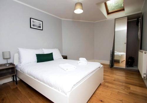 a bedroom with a white bed and a mirror at Westciti Caroco Aparthotel in Croydon