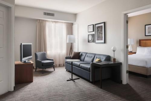 une chambre d'hôtel avec un canapé et un lit dans l'établissement Residence Inn Poughkeepsie, à Poughkeepsie