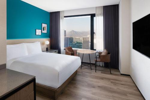 a hotel room with a bed and a table and a window at Four Points by Sheraton Josun, Seoul Myeongdong in Seoul