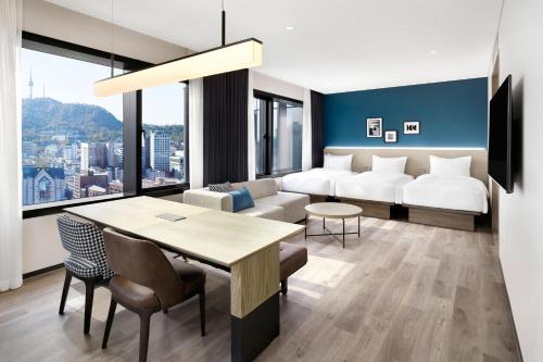 um quarto de hotel com uma cama, uma mesa e cadeiras em Four Points by Sheraton Josun, Seoul Myeongdong em Seul