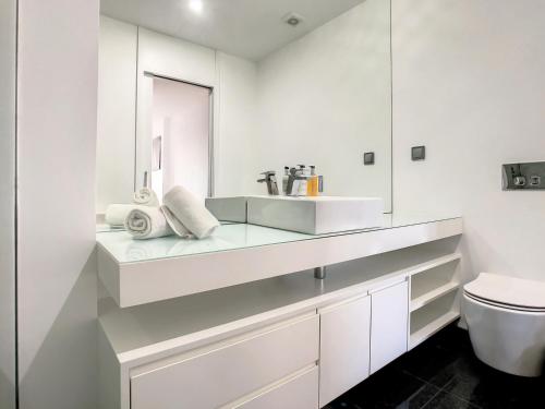 a white bathroom with a sink and a toilet at Lynx Barreiros by LovelyStay in Funchal