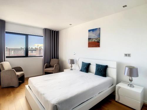 a white bedroom with a large bed and a window at Lynx Barreiros by LovelyStay in Funchal