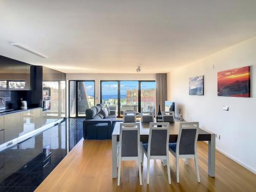 a kitchen and living room with a table and chairs at Lynx Barreiros by LovelyStay in Funchal