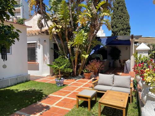 a patio with a couch and a table in a yard at Terra Aloé in Torremolinos