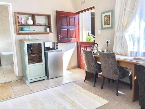 a kitchen with a refrigerator and a table with chairs at Lavender Lane Cottage in Johannesburg