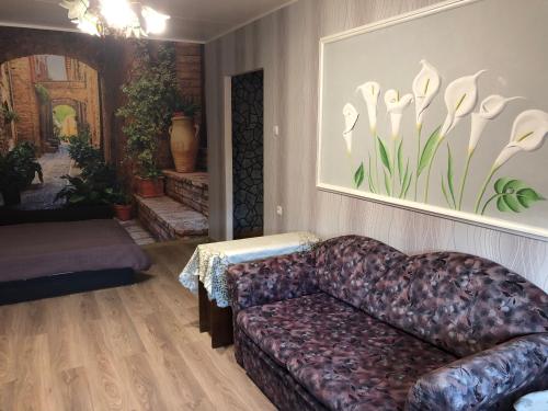 una sala de estar con sofá y una foto de flores en Ahtme mnt apartaments en Ahtme