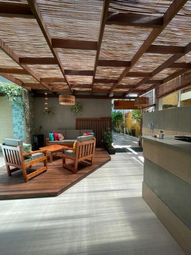 a patio with two wooden chairs and a table at Terra Bella Pousada in Morro de São Paulo