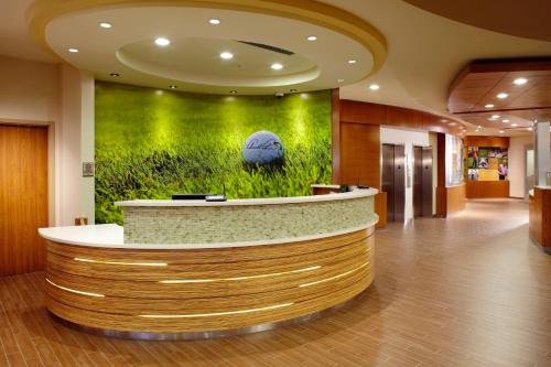 a lobby with a circular counter with a green wall at SpringHill Suites by Marriott Pittsburgh Latrobe in Latrobe