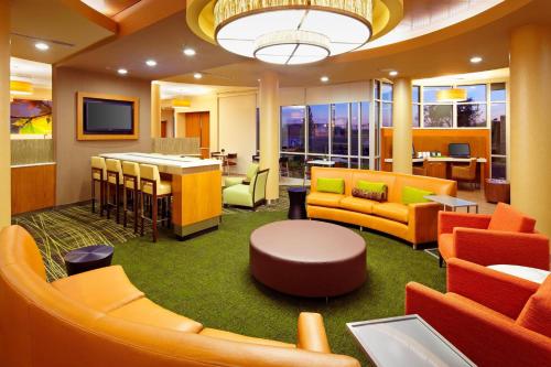 a lobby with orange and yellow furniture and a bar at SpringHill Suites by Marriott Pittsburgh Latrobe in Latrobe