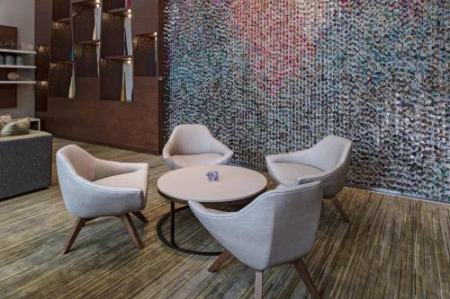 a lobby with chairs and a table and a large painting at Courtyard by Marriott Guatemala City in Guatemala