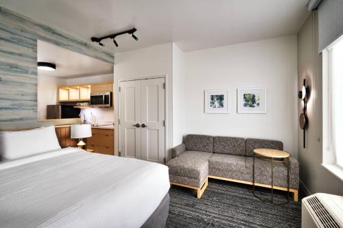 TownePlace Suites Salt Lake City Murray في موراي: غرفه فندقيه بسرير واريكه