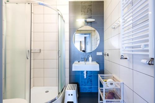 a bathroom with a shower and a sink and a mirror at Pensjonat Nautilus in Karwia