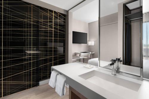 uma casa de banho com um lavatório e um espelho em AC Hotel by Marriott Santa Rosa Sonoma Wine Country em Santa Rosa
