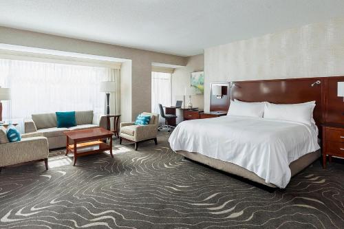 Habitación de hotel con cama y sala de estar. en Rochester Marriott Mayo Clinic Area, en Rochester