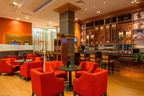 un restaurante con sillas rojas y un bar en Rochester Marriott Mayo Clinic Area, en Rochester