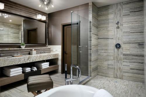 a bathroom with a shower and a sink and a tub at The Josie Hotel, Autograph Collection in Rossland