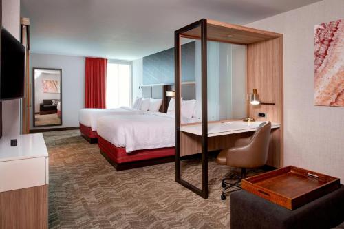 SpringHill Suites by Marriott Grand Rapids West في غراندفيل: غرفه فندقيه بسرير وحمام