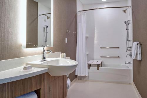 a bathroom with a sink and a shower and a tub at SpringHill Suites by Marriott Grand Rapids West in Grandville