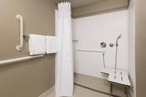 bagno con doccia e asciugamani bianchi di SpringHill Suites Louisville Hurstbourne/North a Louisville