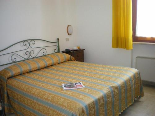 a bedroom with a bed with a book on it at Hotel I Platani in Siena