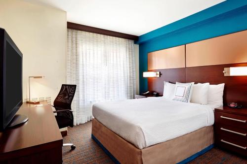 a hotel room with a bed and a flat screen tv at Residence Inn Houston by The Galleria in Houston