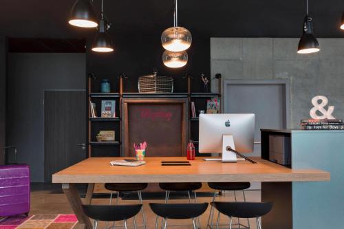 een tafel met een laptop erop bij Moxy Stuttgart Airport/Messe in Leinfelden-Echterdingen