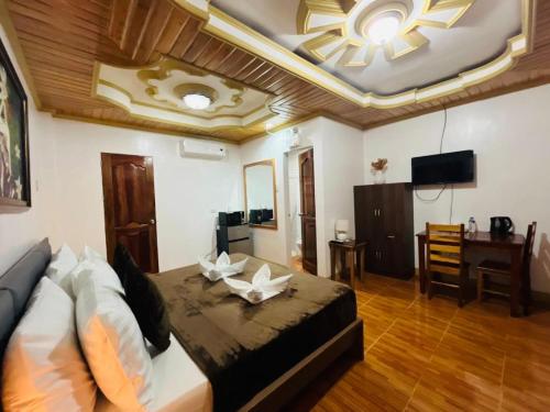 Habitación con cama, escritorio y TV. en Villa Marii, en Dipólog