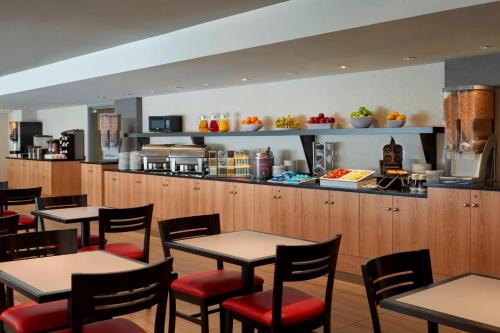 a restaurant with tables and chairs and a kitchen at Residence Inn by Marriott Montréal Downtown in Montreal