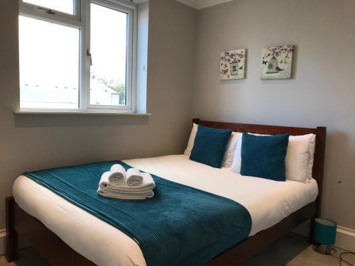 a bedroom with a bed with towels on it at 25 Ongar Road by Viridian Apartments in London