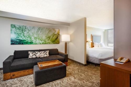 um quarto de hotel com um sofá e uma cama em SpringHill Suites by Marriott Miami Airport South Blue Lagoon Area em Miami