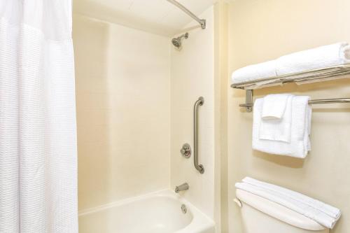 łazienka z toaletą i prysznicem z ręcznikami w obiekcie SpringHill Suites by Marriott Miami Airport South Blue Lagoon Area w Miami