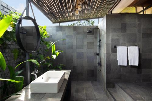 een badkamer met een wastafel en een douche met planten bij Natra Bintan, a Tribute Portfolio Resort in Lagoi