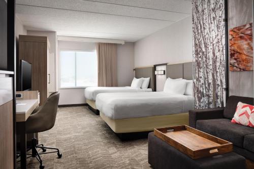 ブルーミントンにあるSpring Hill Suites Minneapolis-St. Paul Airport/Mall Of Americaのベッド2台とソファが備わるホテルルームです。