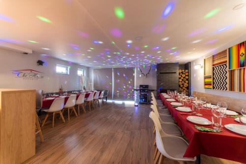 a dining room with a long table and chairs at "The House" Апартаменти и Термална зона in Velingrad