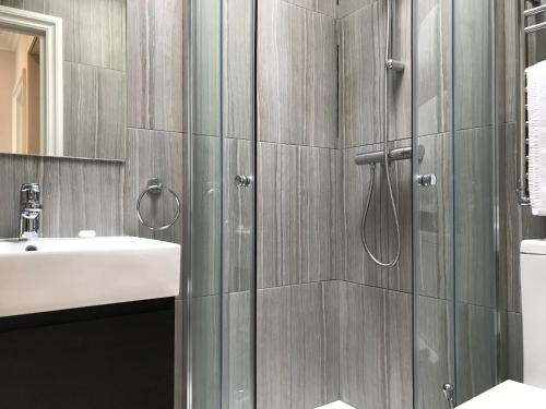 a bathroom with a shower and a sink at 25 Ongar Road by Viridian Apartments in London