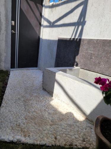 a shadow of a door on a building with a flower pot at Puerto del Cielo in Chuburná