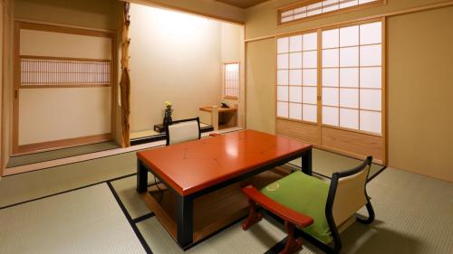 a dining room with a wooden table and chairs at Shibu Onsen KOKUYA in Yamanouchi