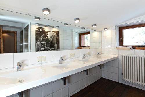 a bathroom with three sinks and a large mirror at Sonnenalm Kampenwand in Aschau im Chiemgau